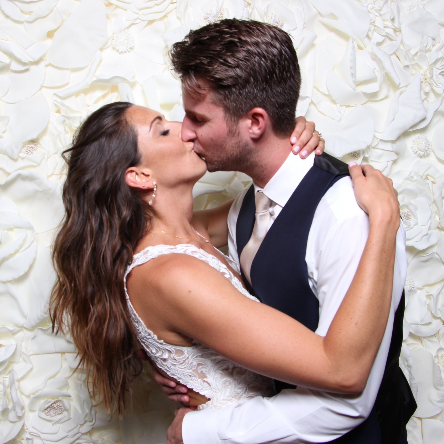 Bride and groom kissing in a photo booth