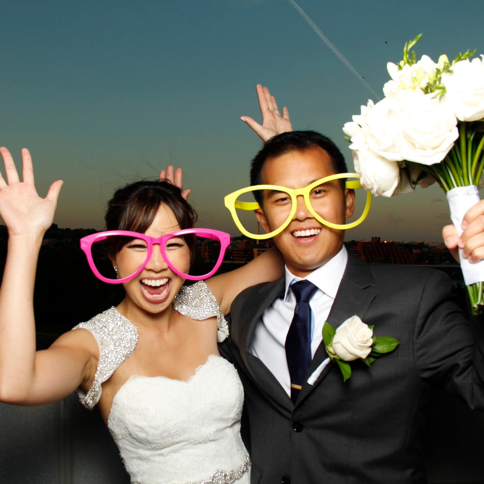Bride and Groom posing in an open-air photo booth in front of a sunset