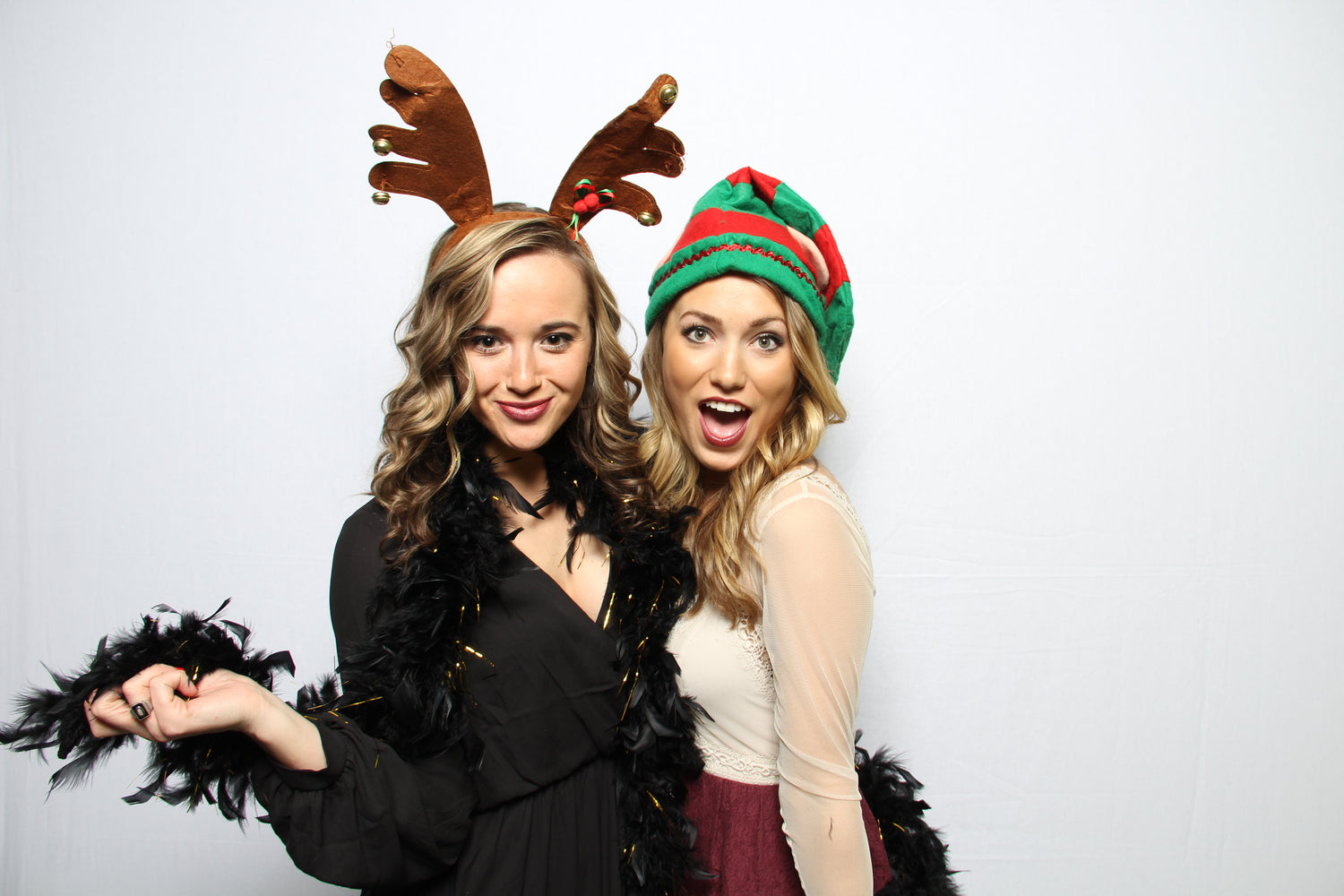 Women in a holiday photo booth with Christmas props