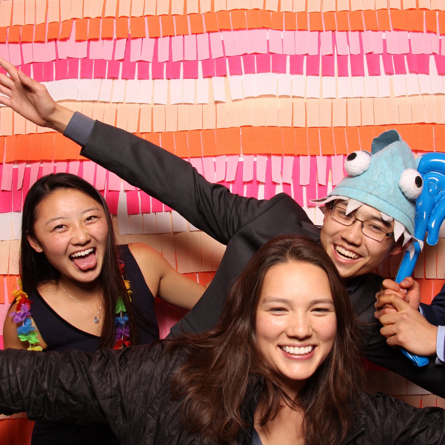 Wedding photo booth fun with props and a DIY paper backdrop