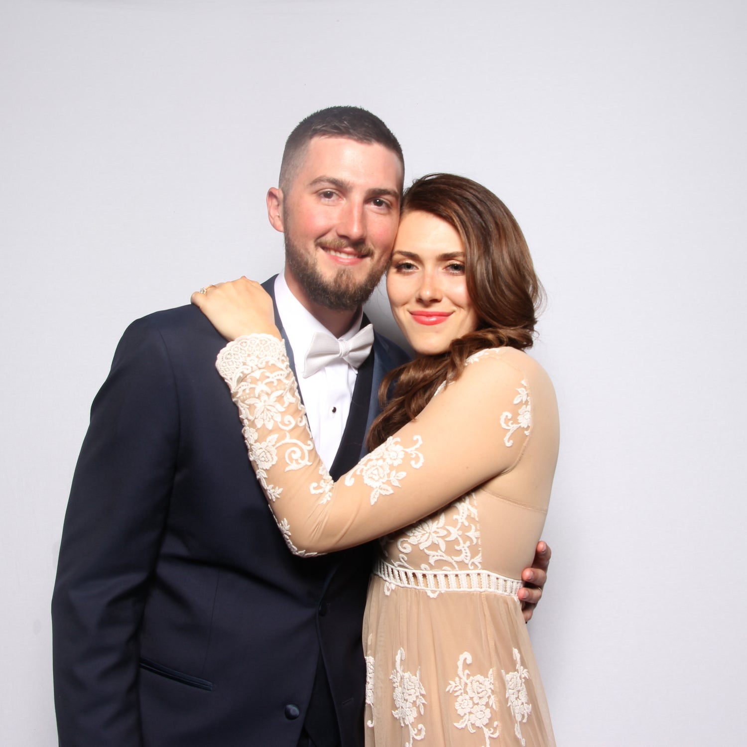 Groom and Bride pose in a photo booth at their wedding