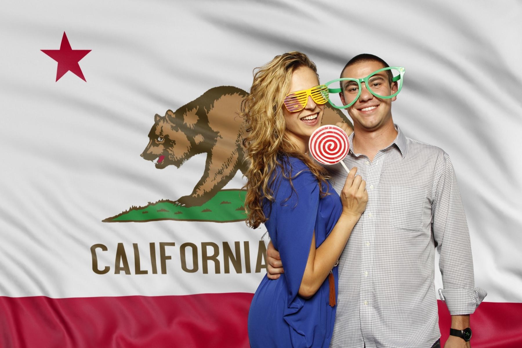 Couple in a photo booth with a California state flag background