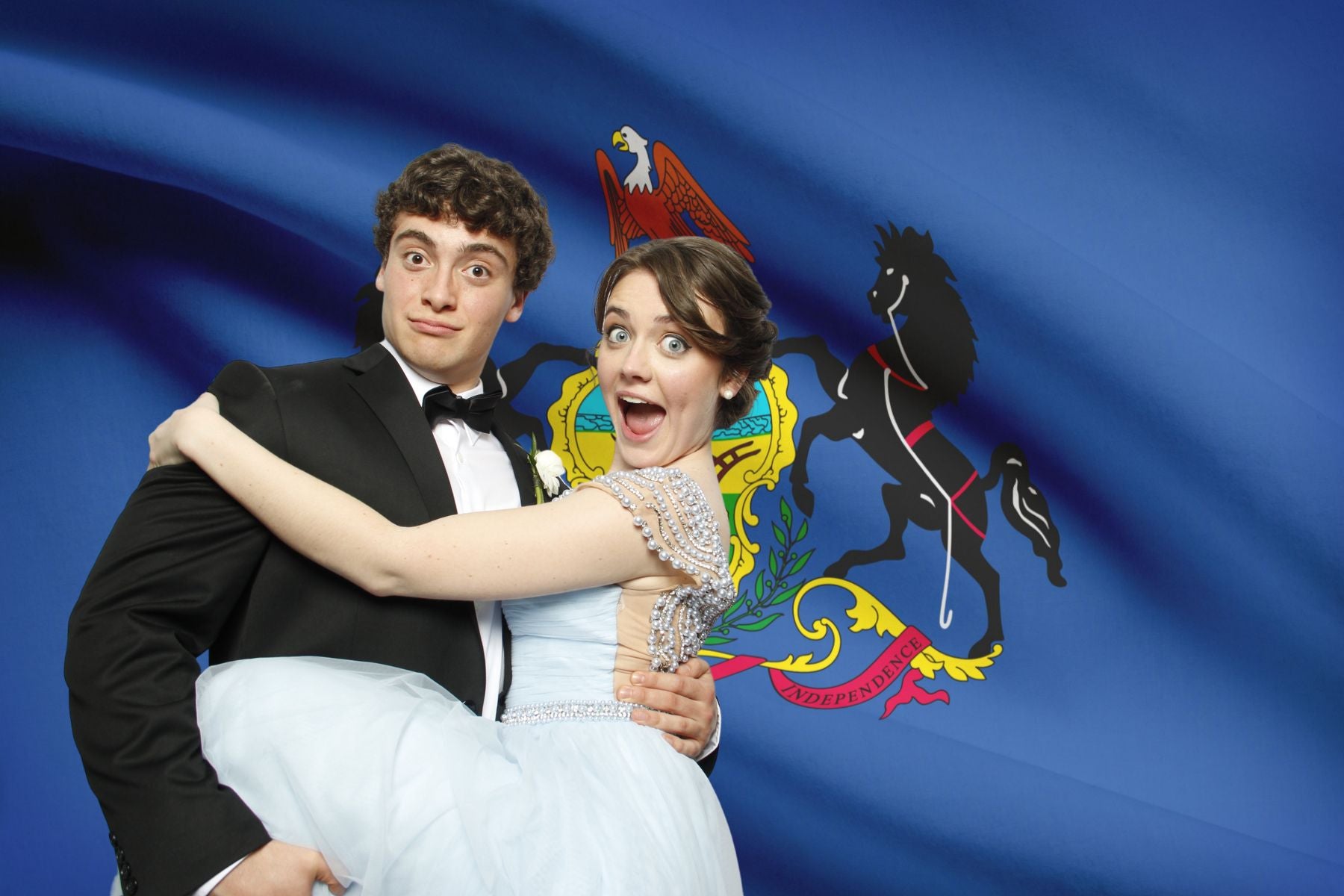 Bride and Groom posing for a wedding photo booth picture in front of a Pennsylvania state flag