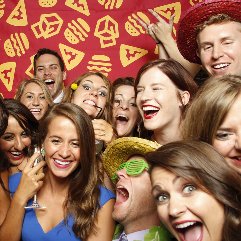 Coworkers having fun in a company party photo booth